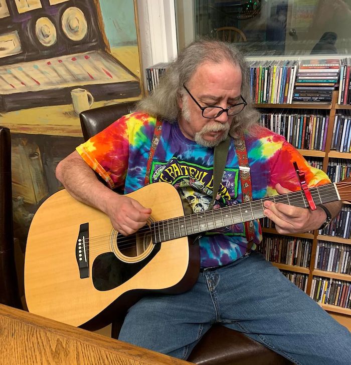 Dan playing his guitar at the studio